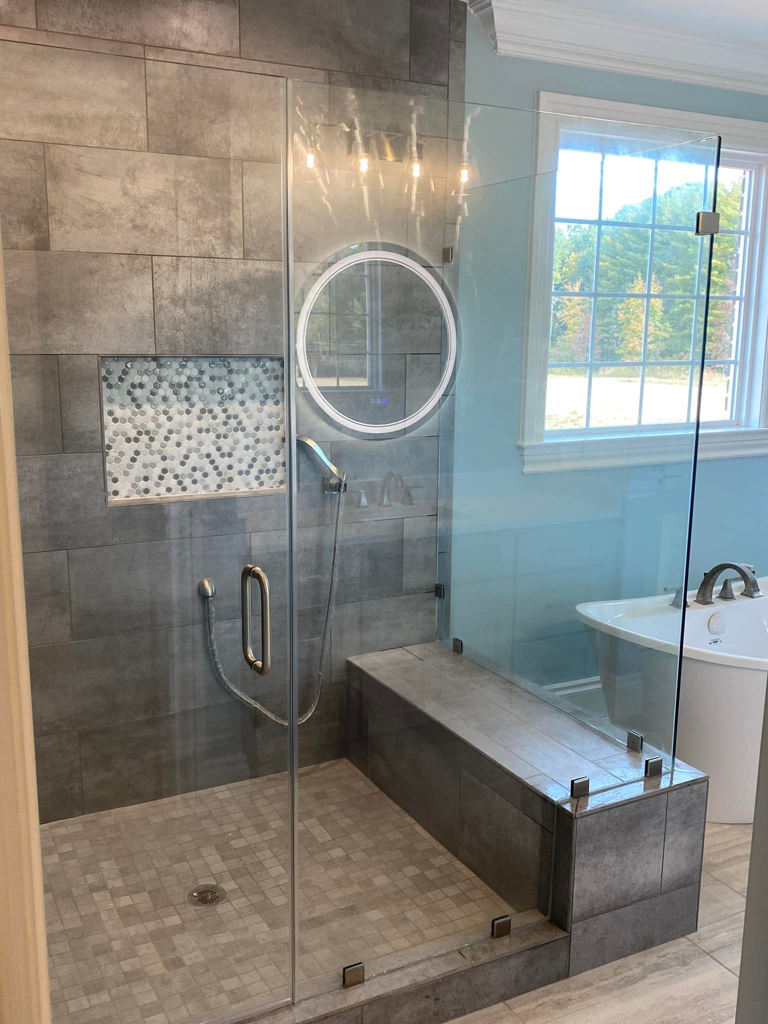 A bathroom with a walk in shower and a bathtub.