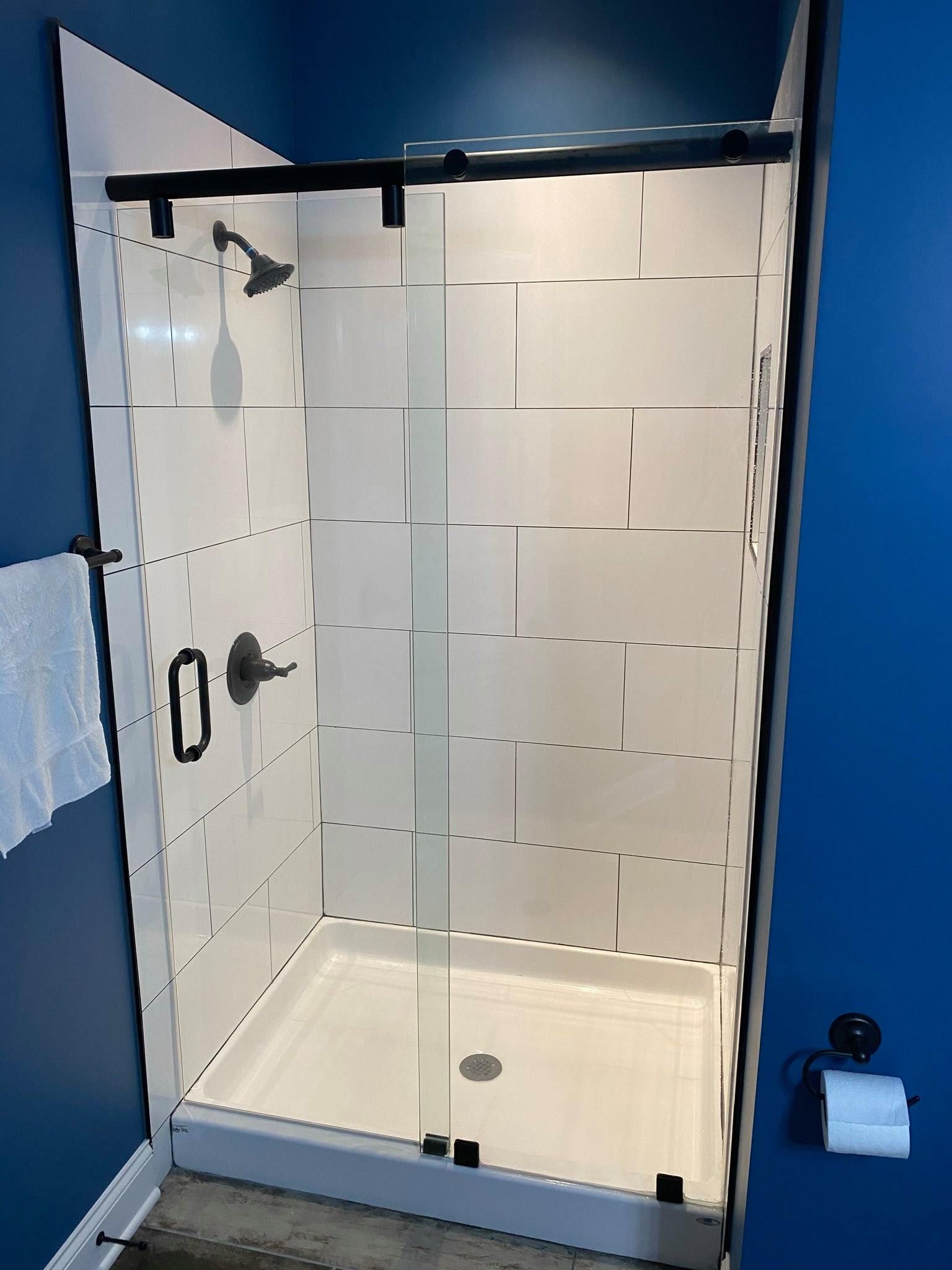 A shower stall with a sliding glass door in a bathroom.