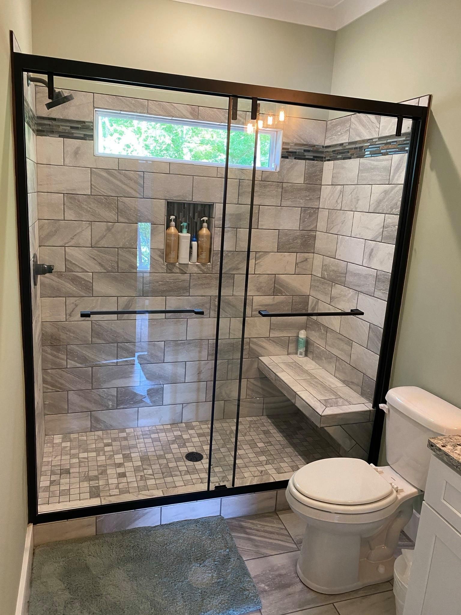 A bathroom with a walk in shower and a toilet.