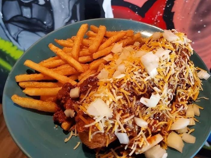 A plate of chili and french fries on a table