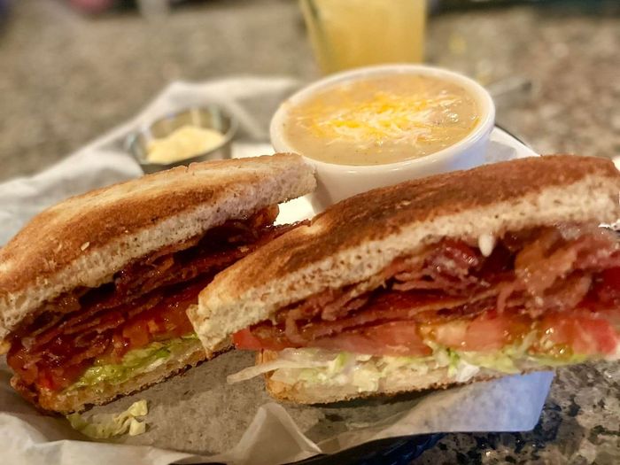 A sandwich and a bowl of soup are on a table.