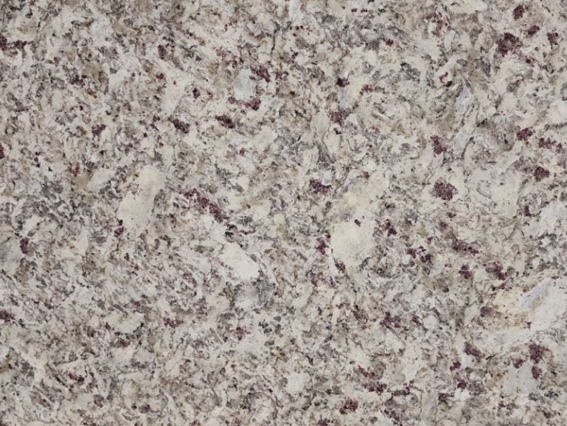 Close-up of granite countertop with white, gray, and small red/purple flecks.
