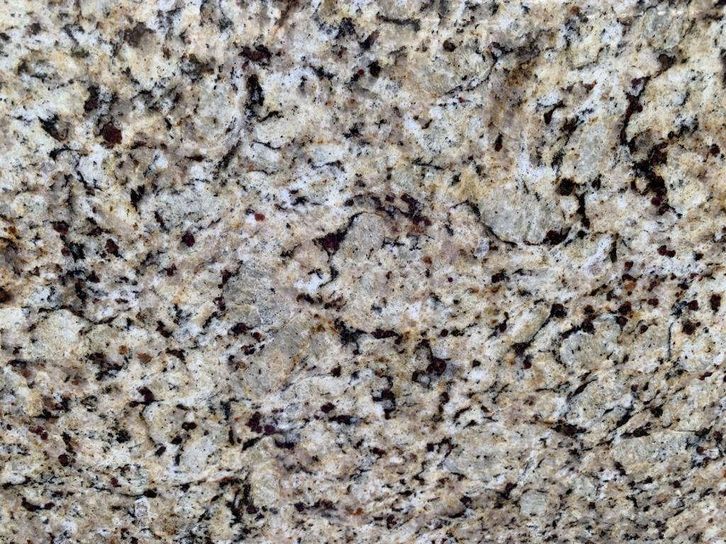 Close-up of granite countertop, tan with dark brown and black flecks.