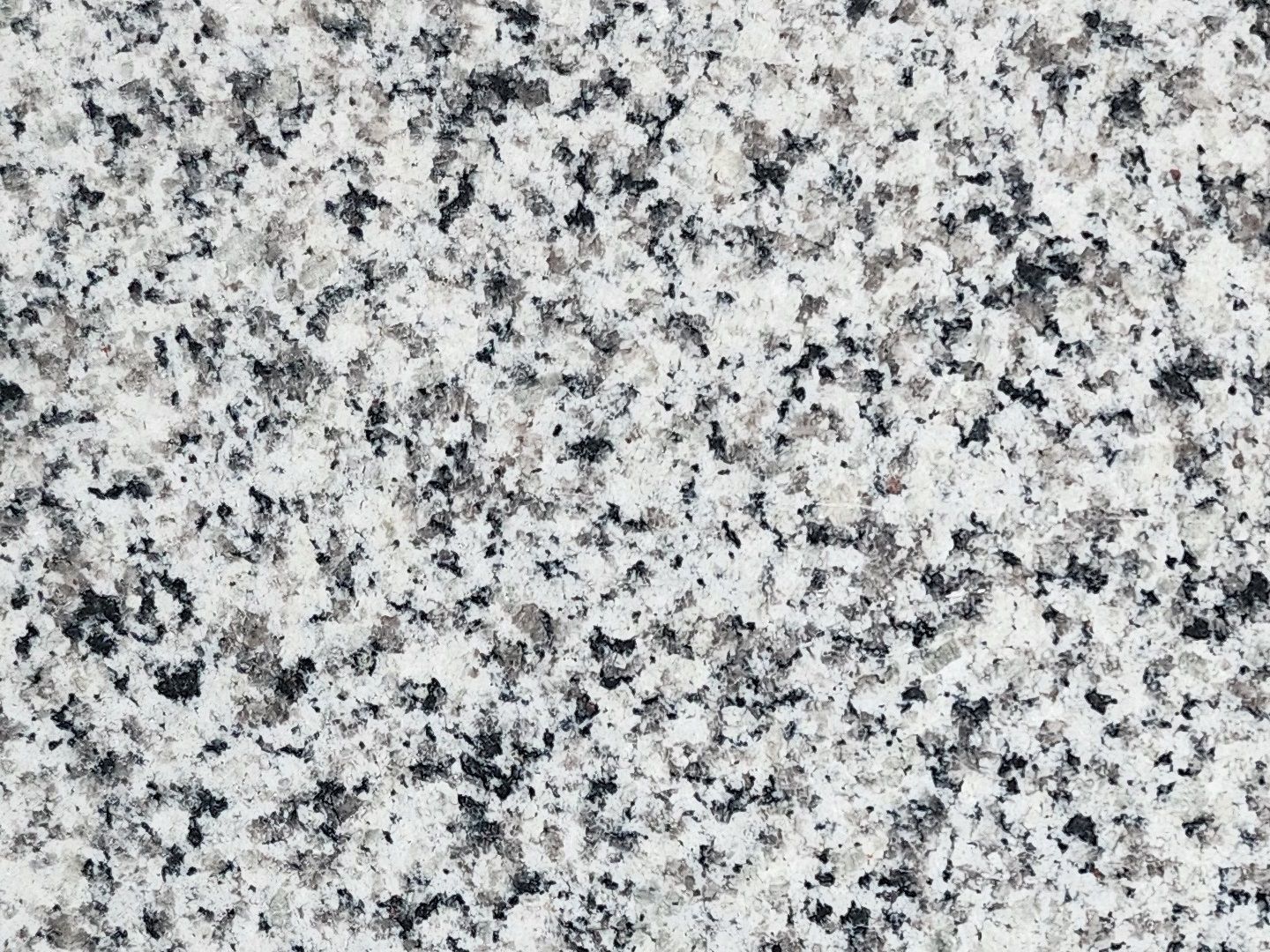 Granite surface, primarily white with speckles of black and gray.