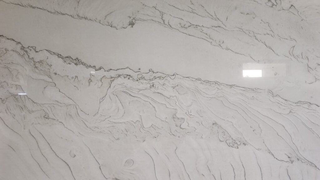 White countertop with grey veining, a shiny surface, likely a kitchen or bathroom material.