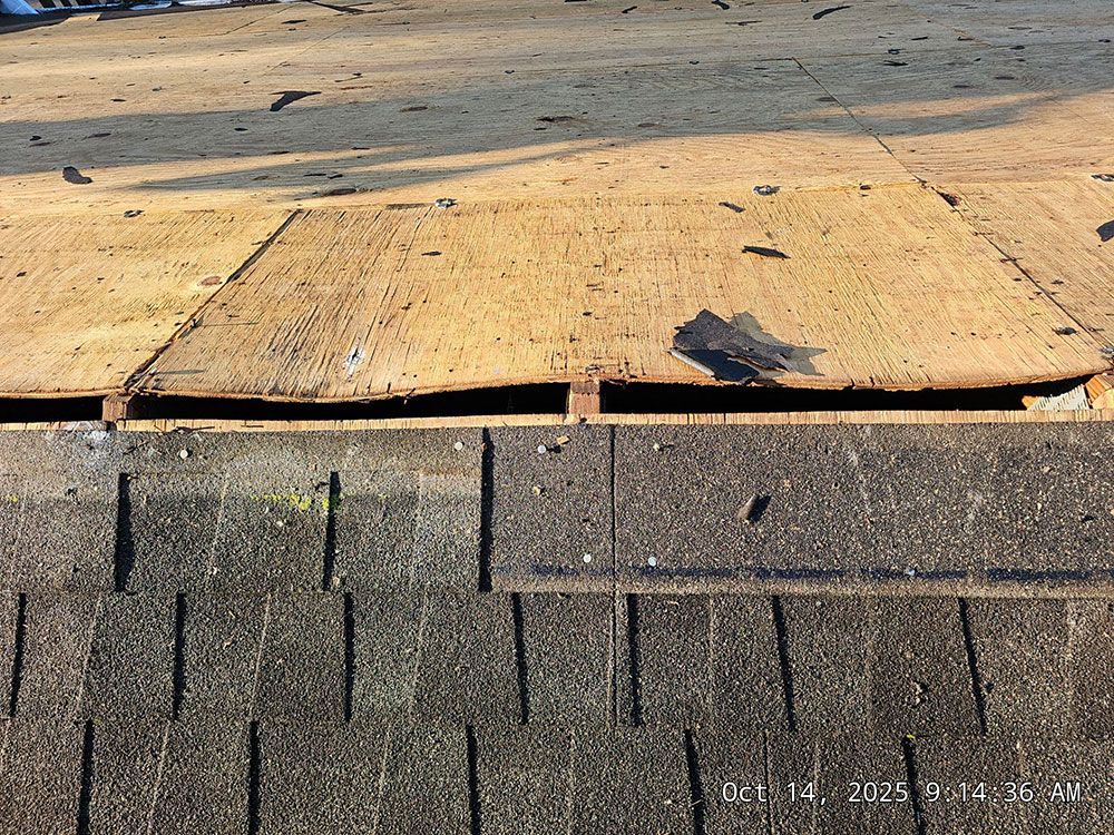Damaged roof showing exposed underlayment and missing shingles.
