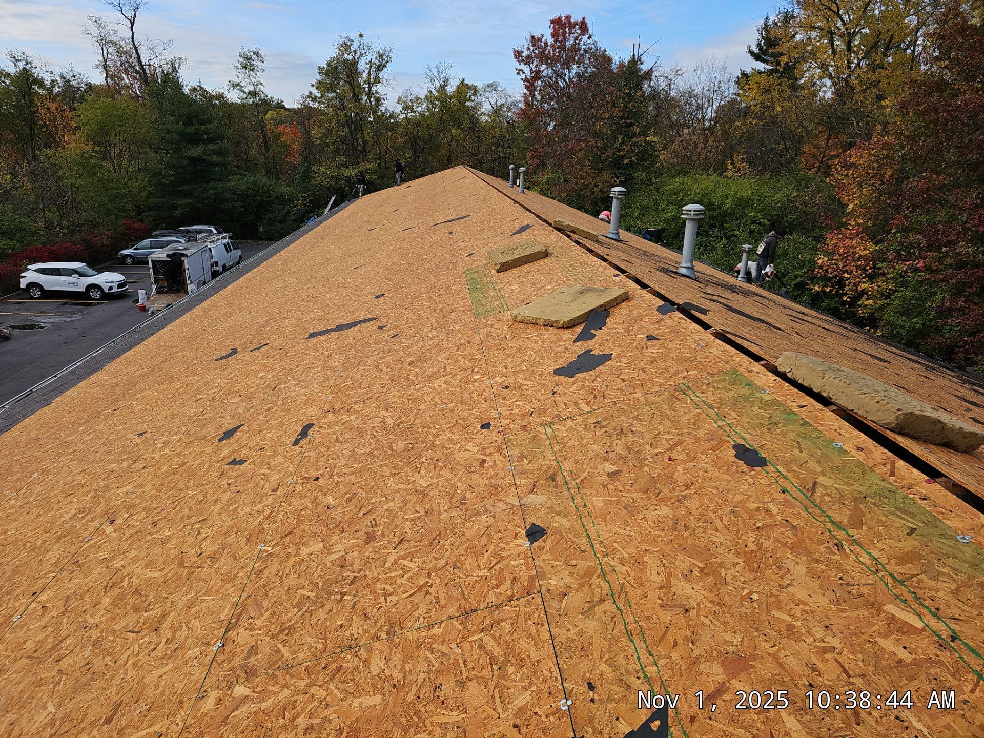 A roof under construction, covered in wood panels, with insulation in place.
