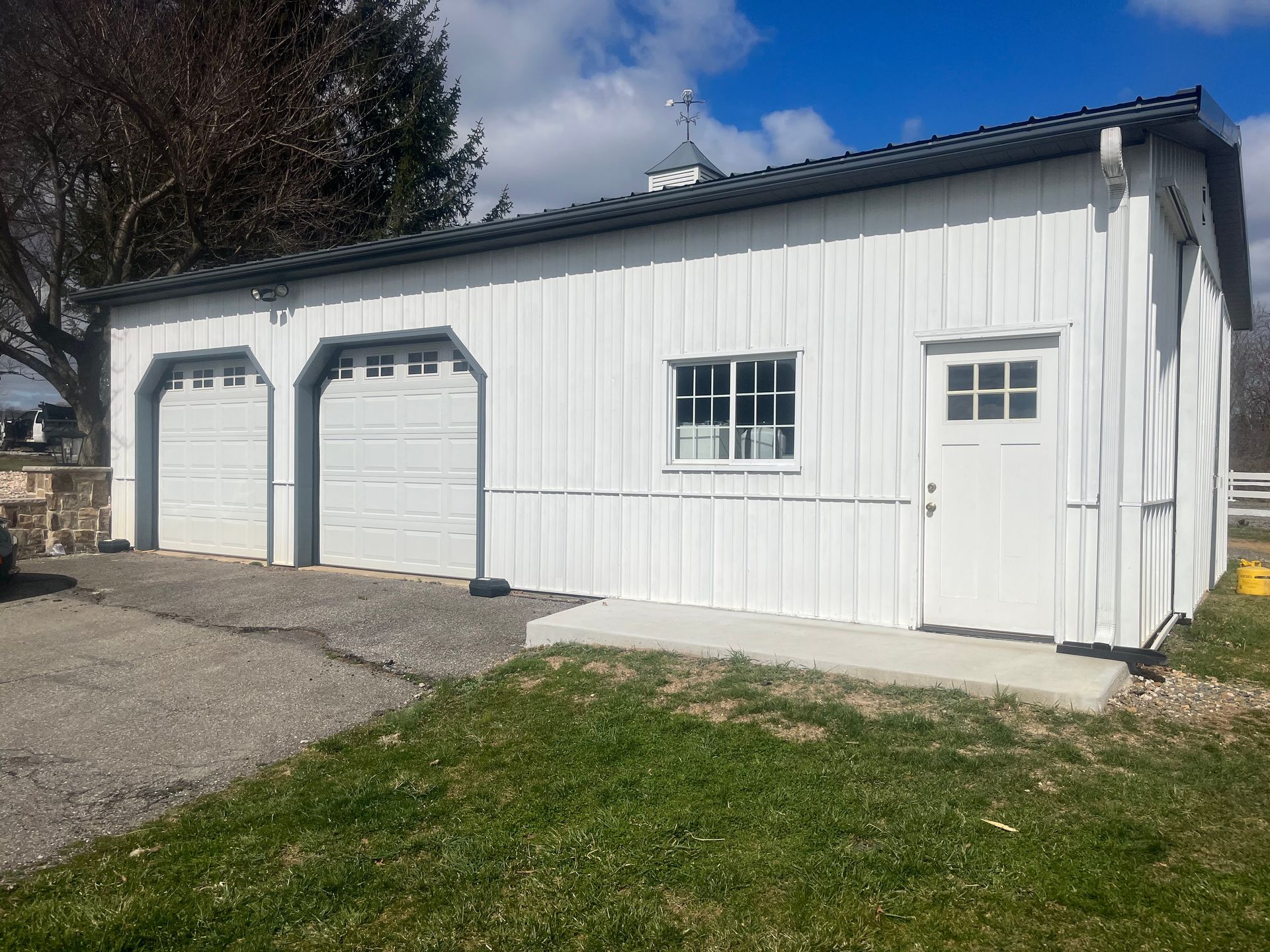A white garage with two garage doors and a window.