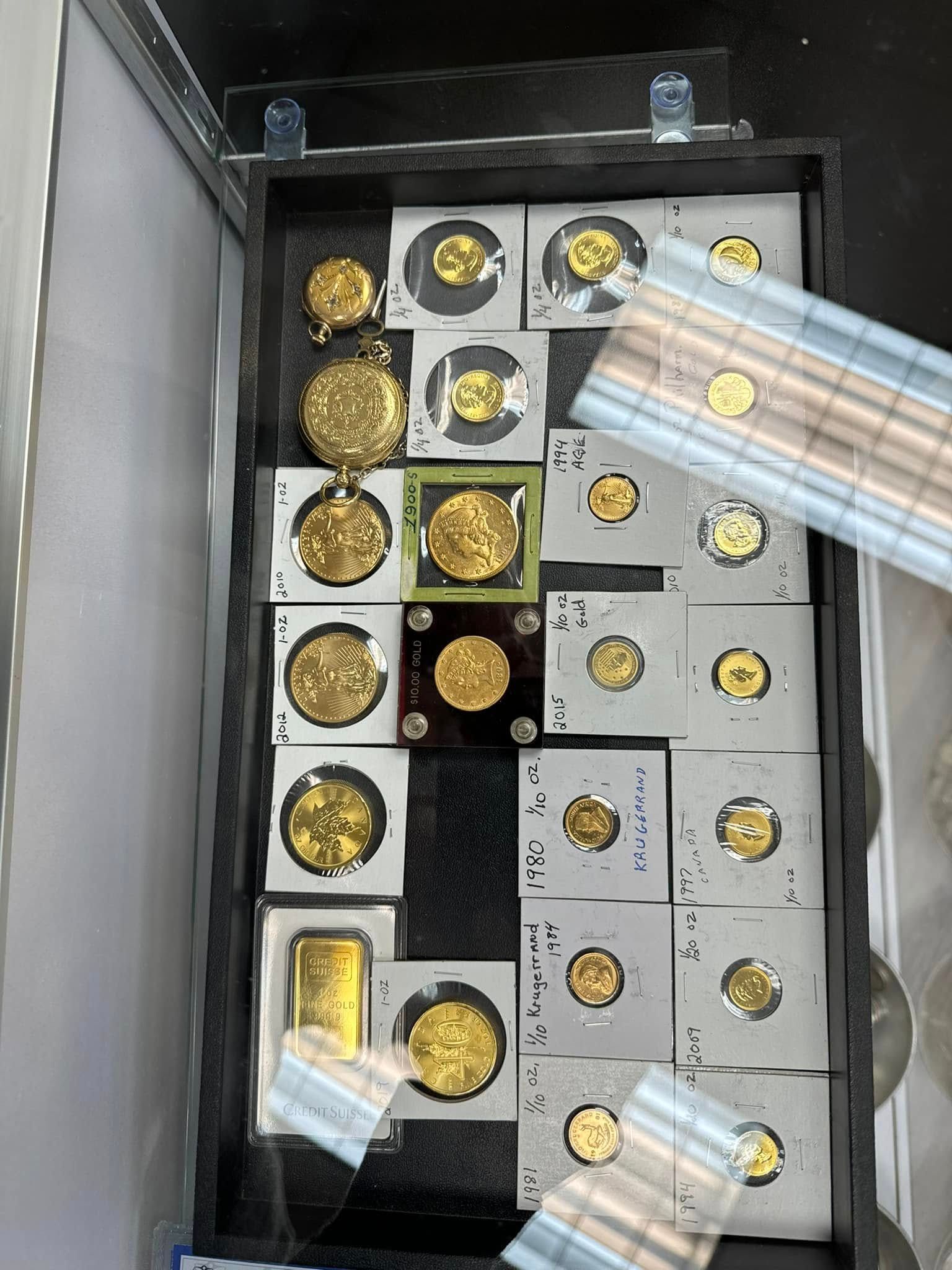 Open safe with gold coins and bars arranged in compartments