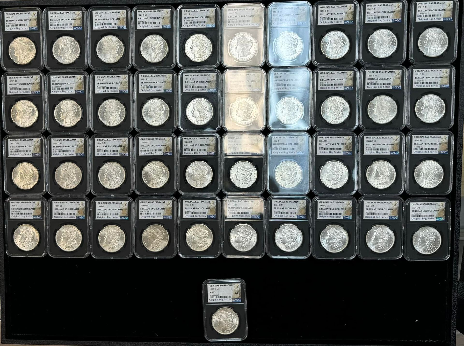 A tray of many small coin or token packets arranged in rows, with one packet centered below.