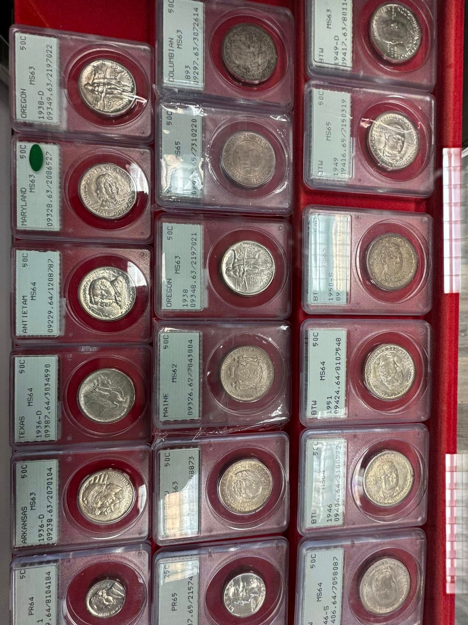 Red and maroon display cases with shiny silver coins arranged in rows on a shelf