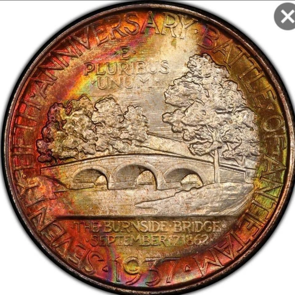 Colorful commemorative coin featuring a stone bridge and trees, with text around the rim.
