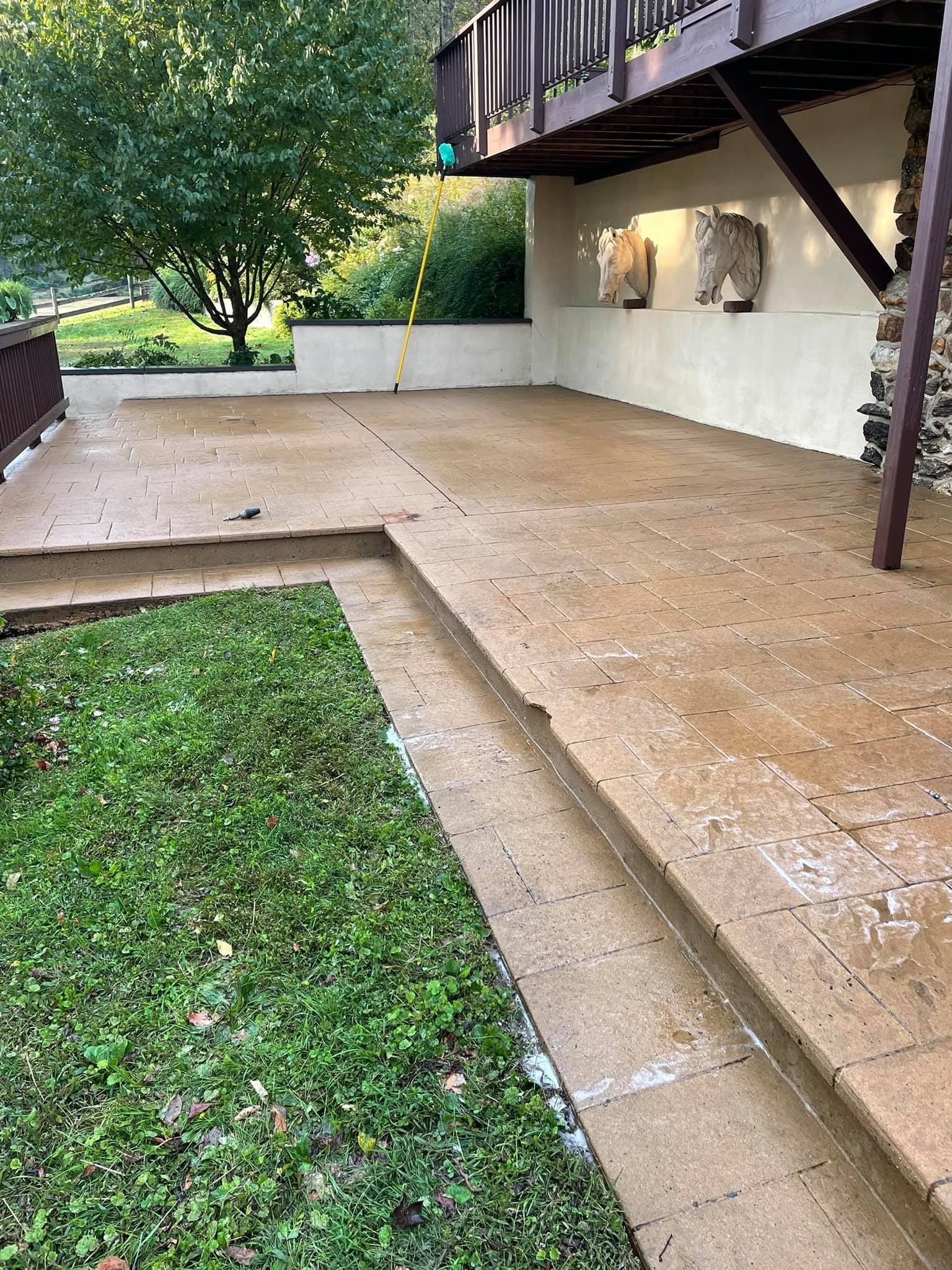 Concrete patio with adjacent grass and elevated wooden deck.