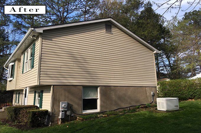 After photo of a beige two-story house with tan siding and a grassy yard