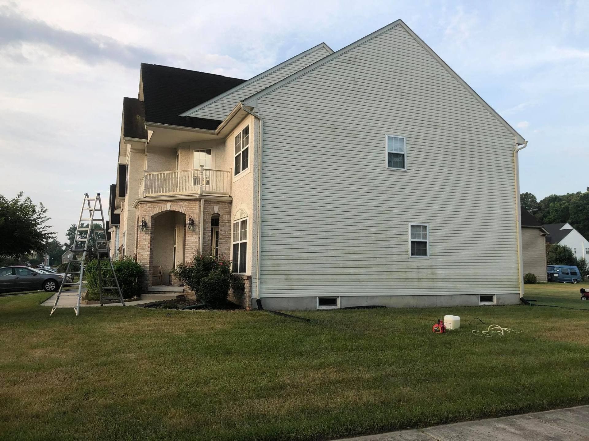 Damaged two-story house with missing roof and exposed framing, viewed from the lawn.