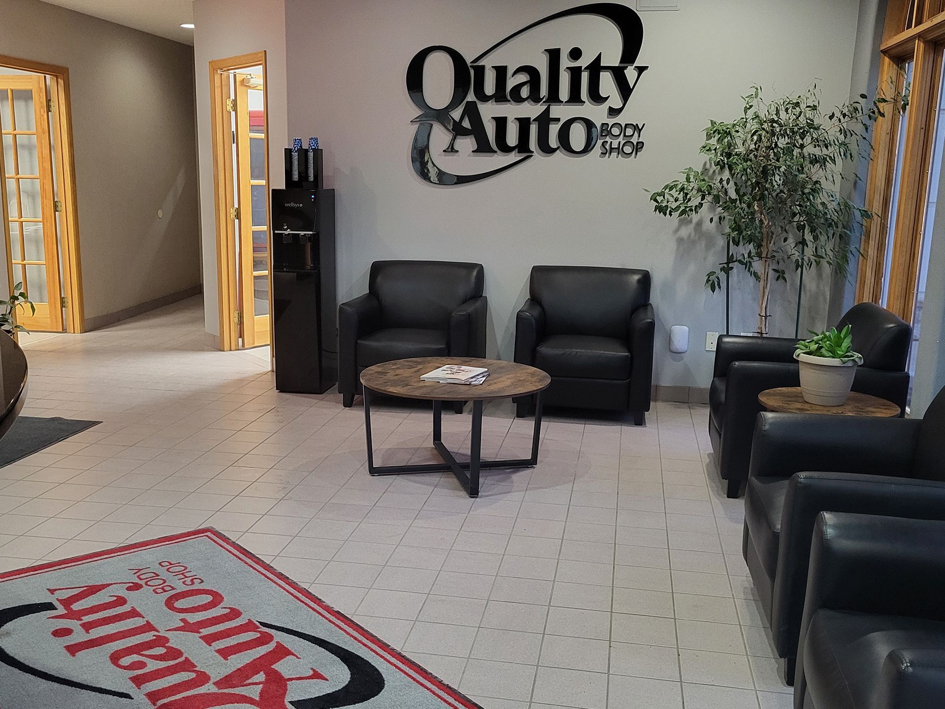 A waiting room with chairs and a sign that says quality auto