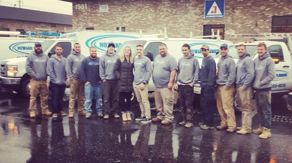 A group of people are posing for a picture in front of a building.