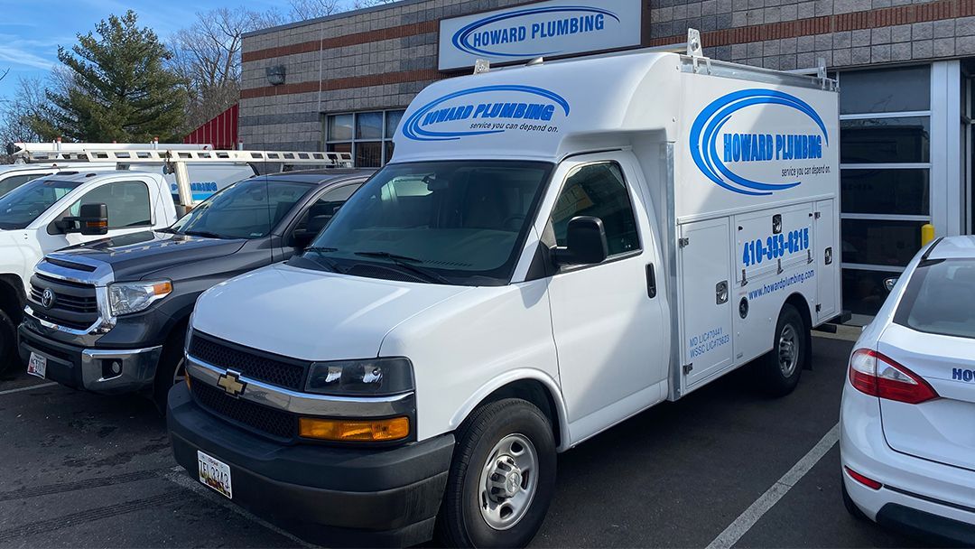 A white van is parked in a parking lot next to a building.