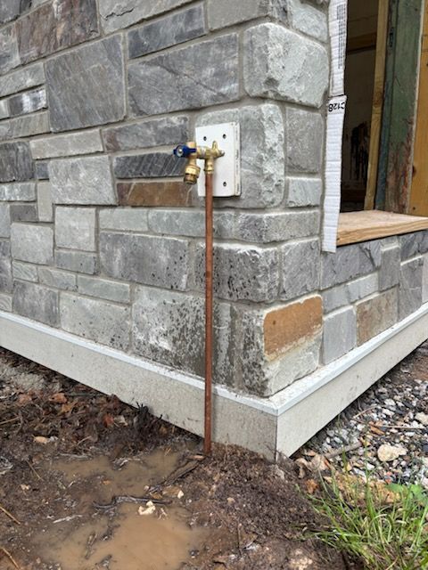 A brick wall with a faucet attached to it