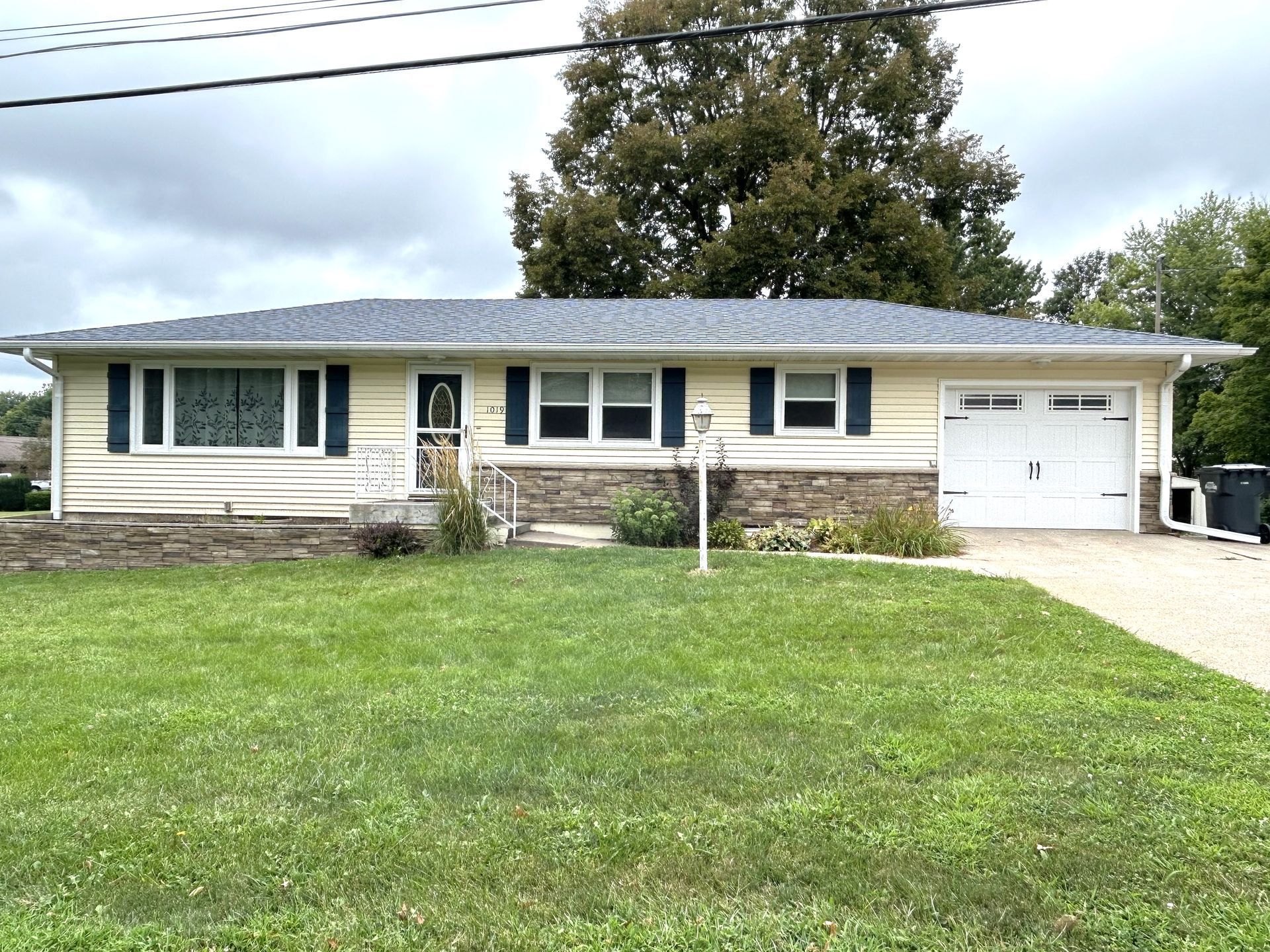 A house with a large lawn in front of it and a garage