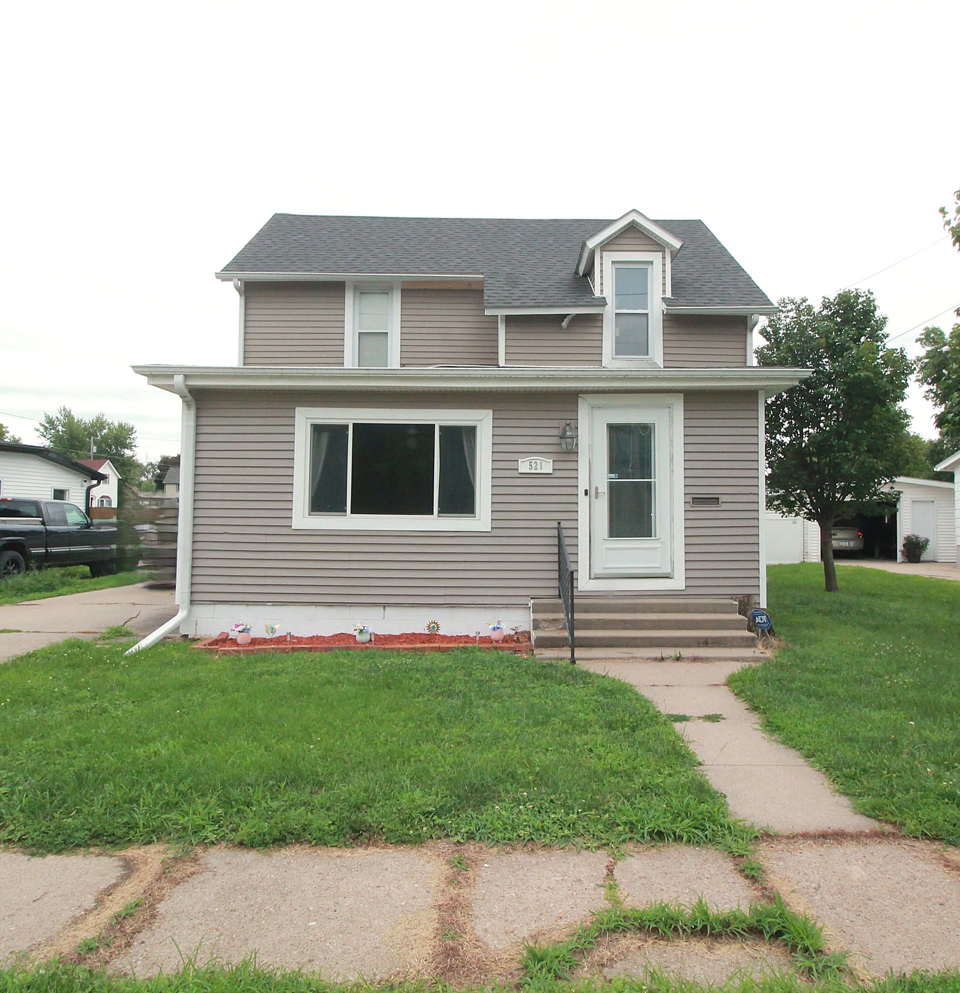 A house with a gray siding and a black roof