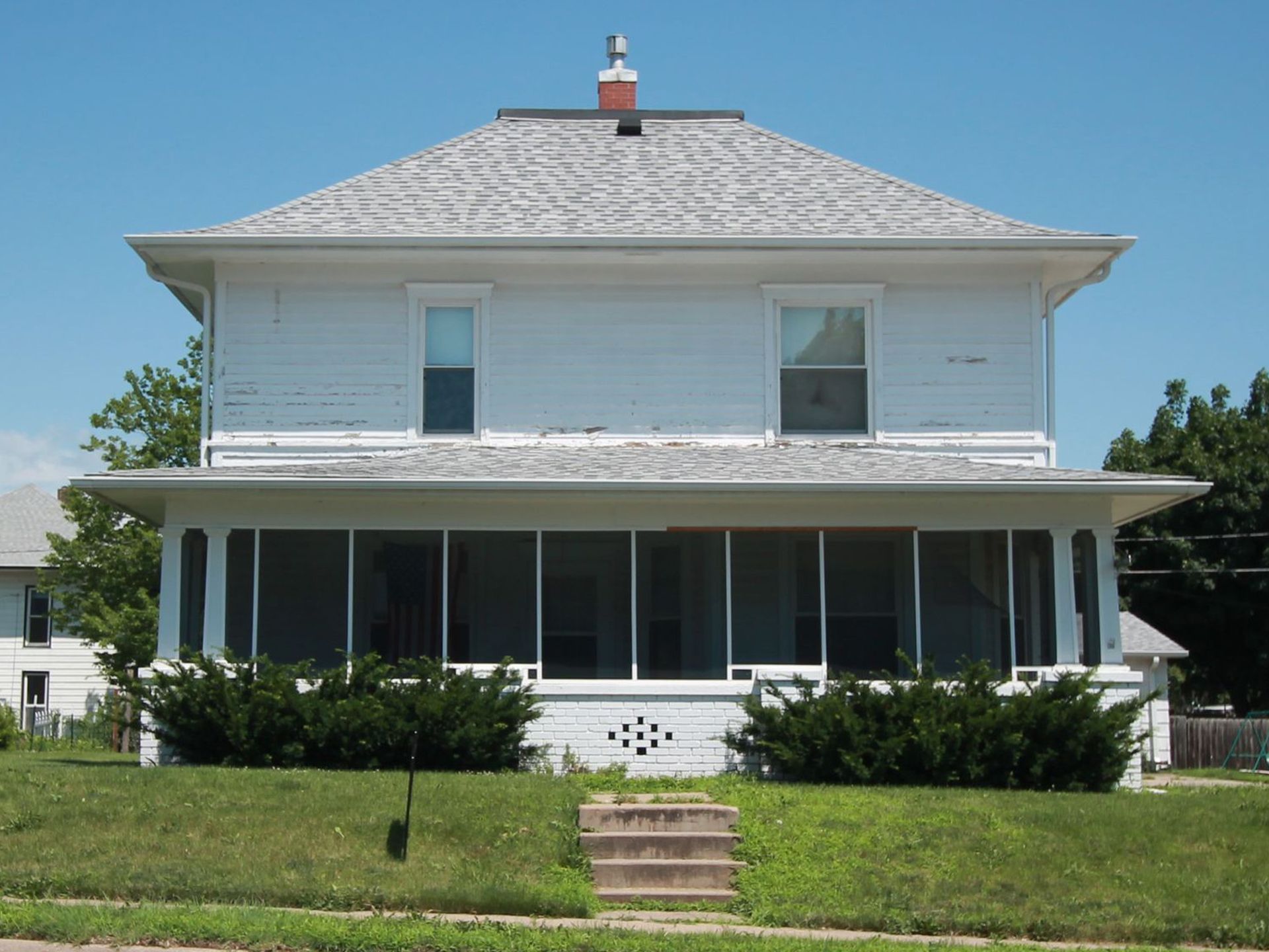 A white house with a chimney on top of it