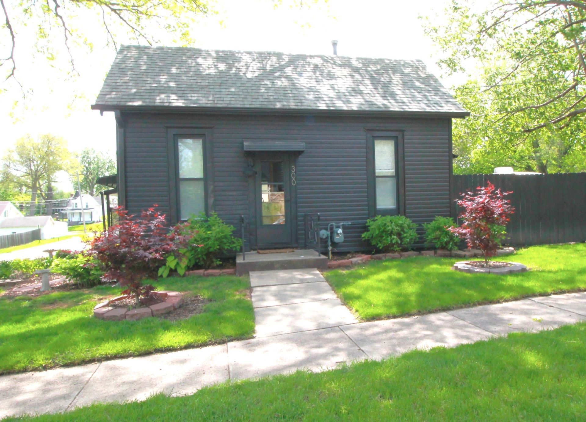 A small black house with a walkway leading to it