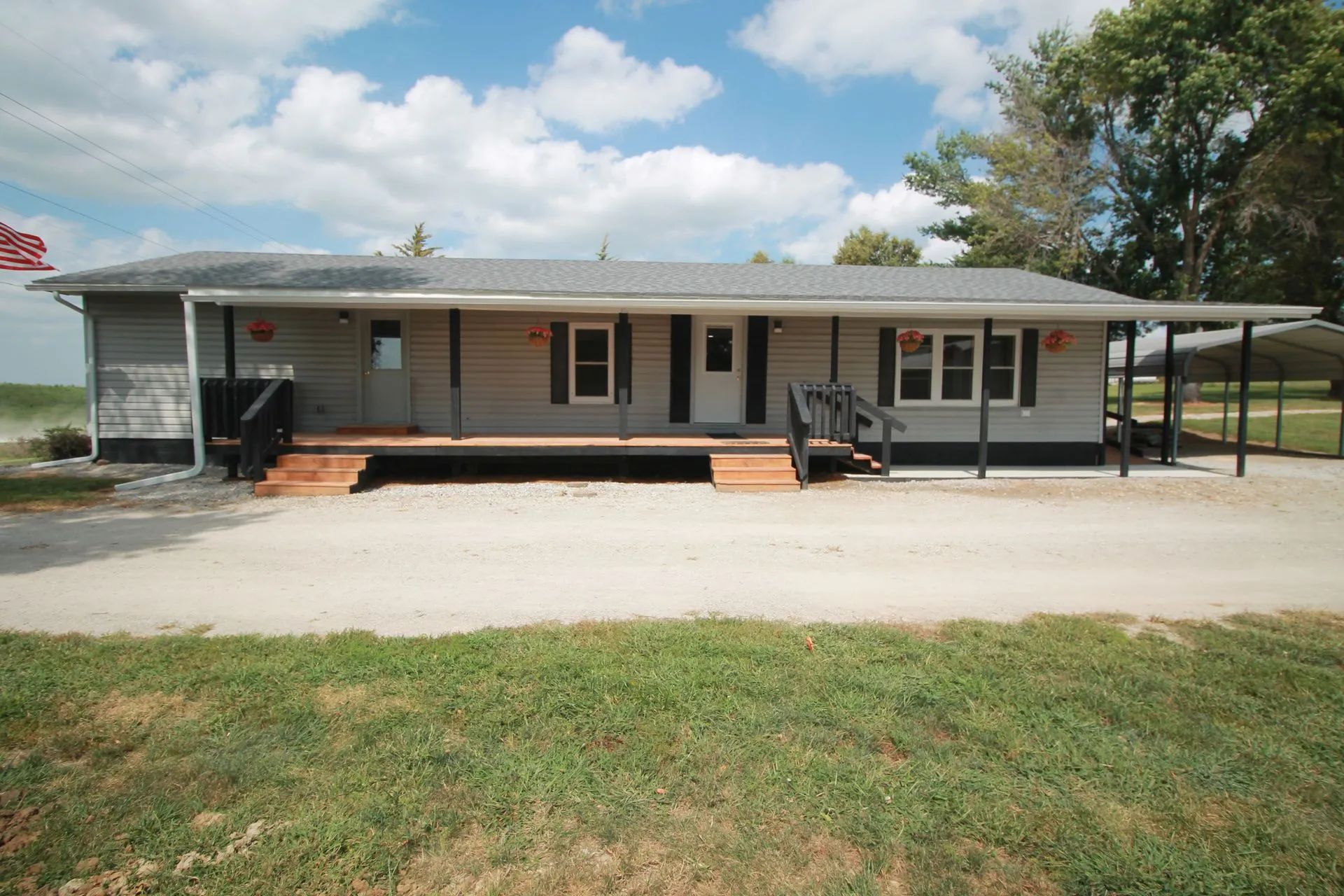 A house with a large porch and a carport