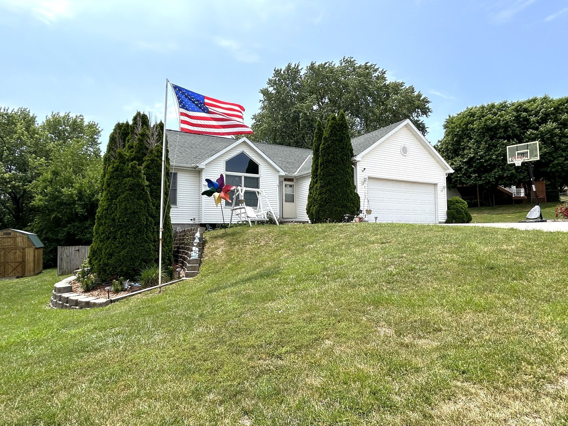 White house with trees and American flag 2101 Sunny Slope Dr.  Red Oak, IA