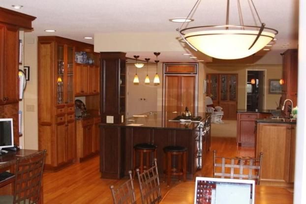 A kitchen with wooden cabinets and a large island