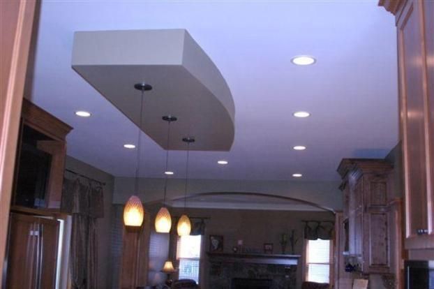 A kitchen with a white ceiling and a few lights hanging from it