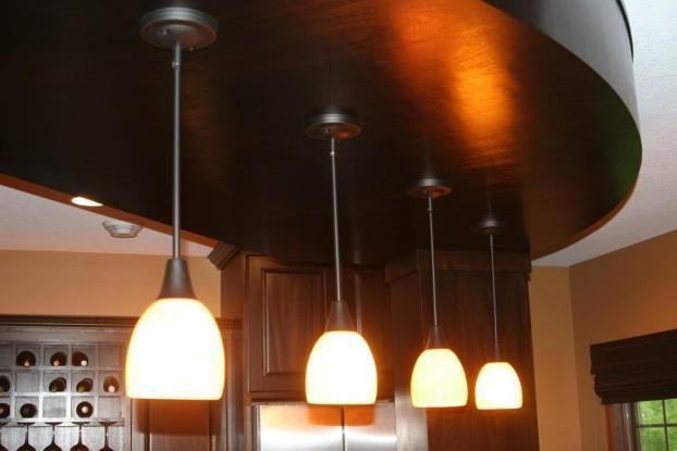 A row of pendant lights hanging from the ceiling in a kitchen