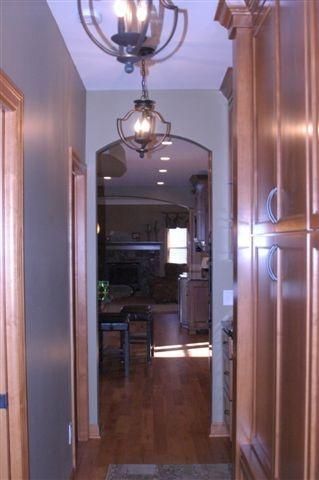 A hallway in a house with a chandelier hanging from the ceiling.