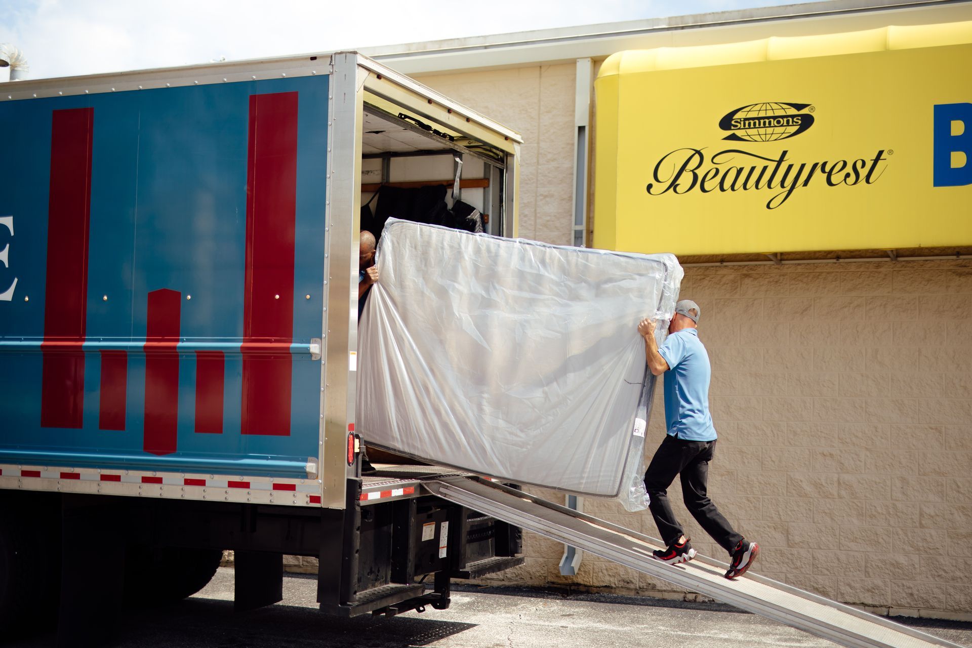 Worker loading a mattress into a truck at a Beautyrest facility