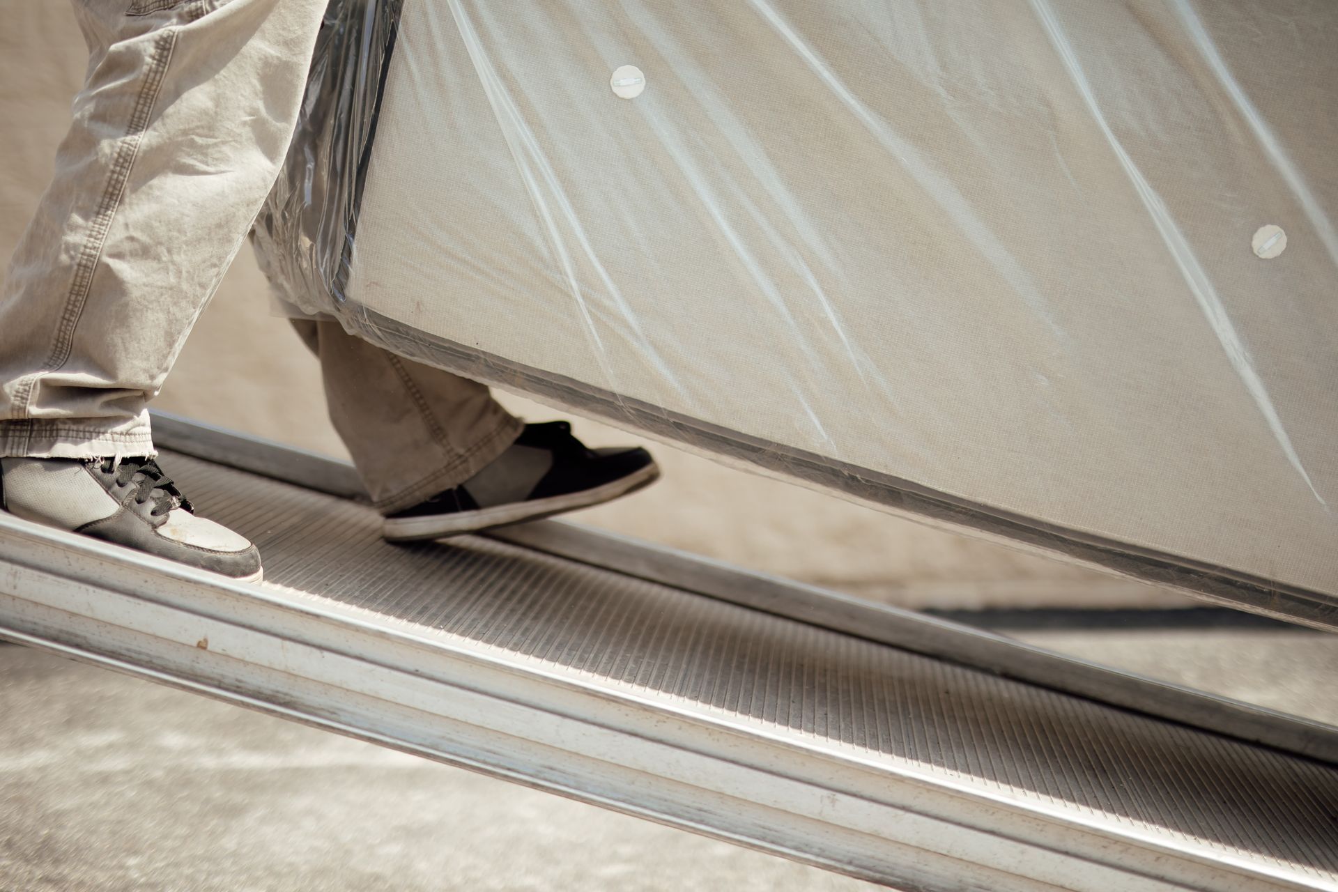 Close-up of two people’s feet walking by a tent flap, one in sneakers and one in black shoes.