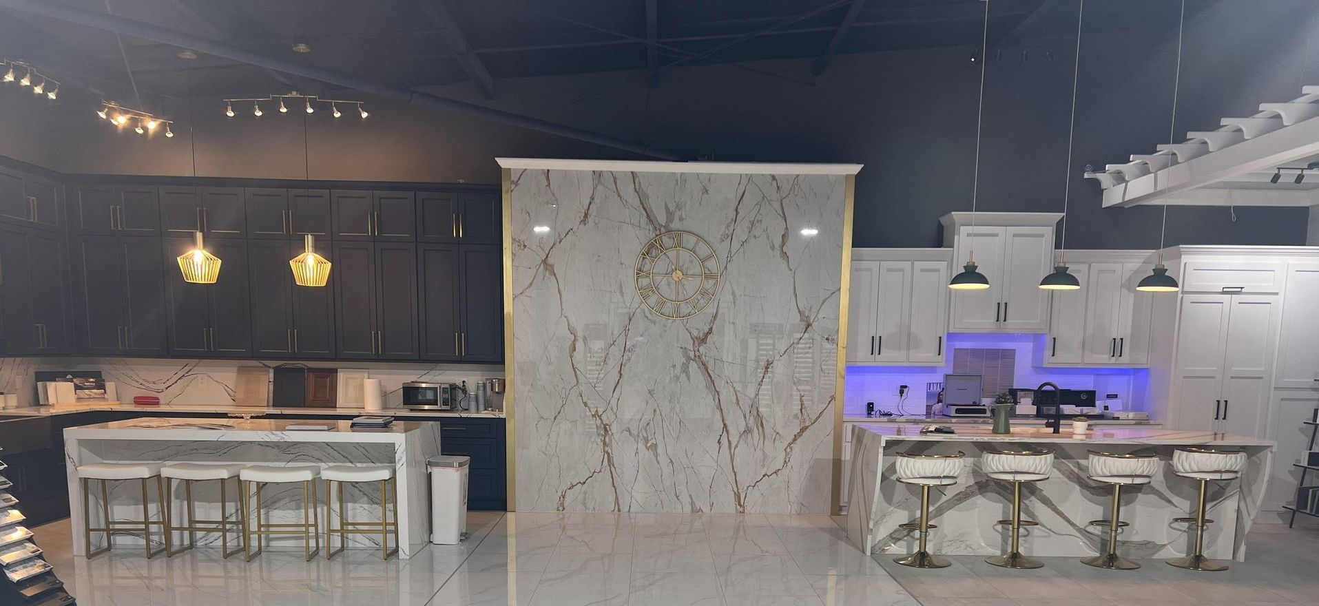 Kitchen showroom with multiple islands, cabinets, and decorative lighting.