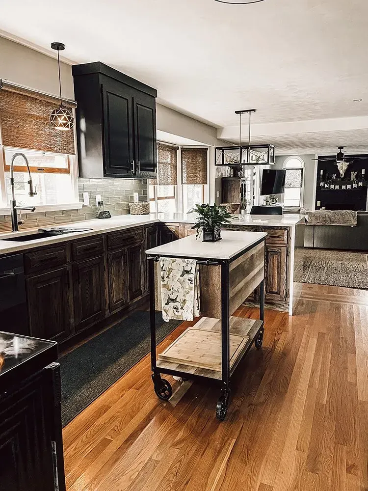 Kitchen with dark wood cabinets, a rolling island, and hardwood floors.