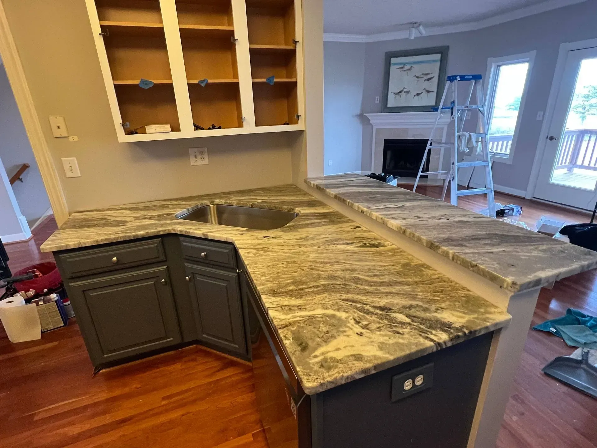 Kitchen remodel: dark gray cabinets, granite countertops, and open upper cabinets.