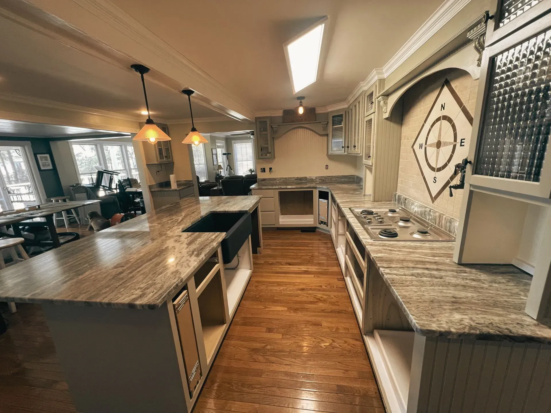 Spacious kitchen with a large island, granite countertops, and light wood floors.