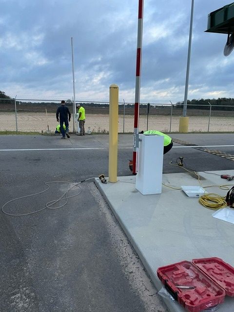 A man in a yellow vest is working on a gate