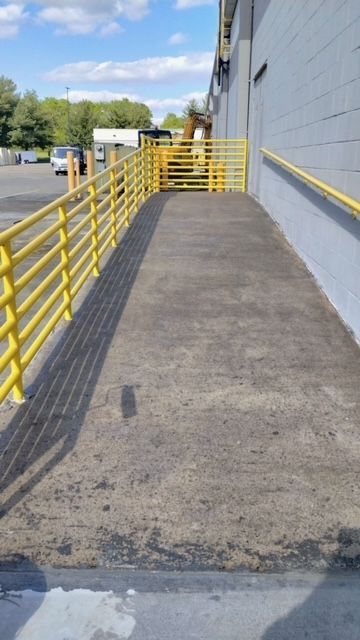 A ramp leading to a building with a yellow railing