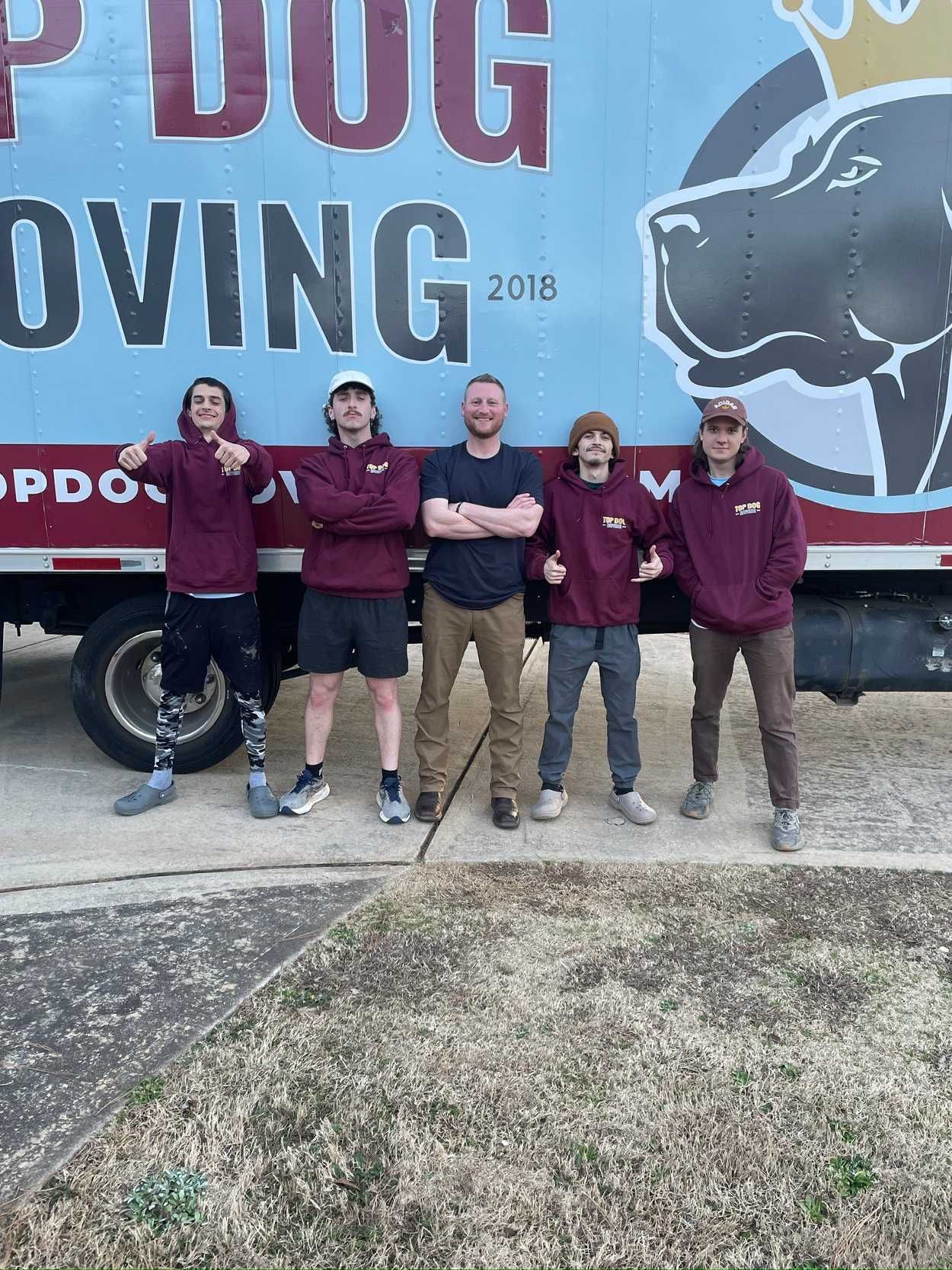 A group of people standing in front of a moving truck.