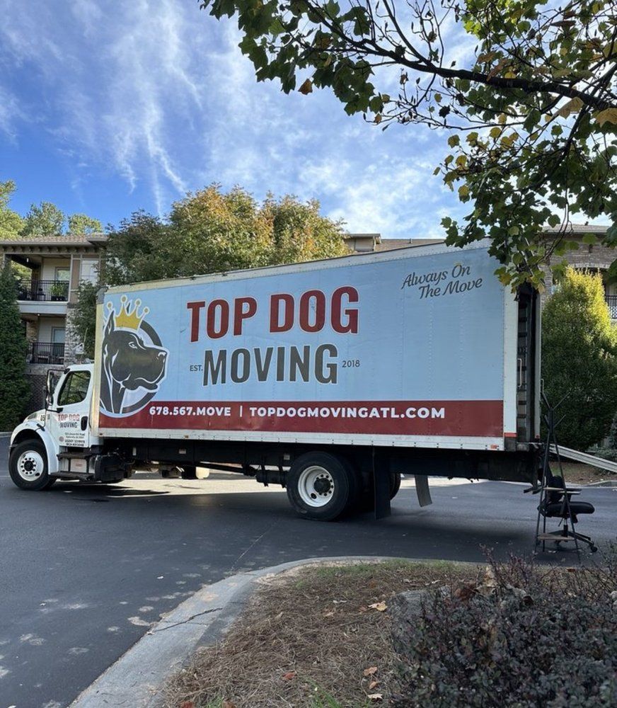 A top dog moving truck is parked on the side of the road.