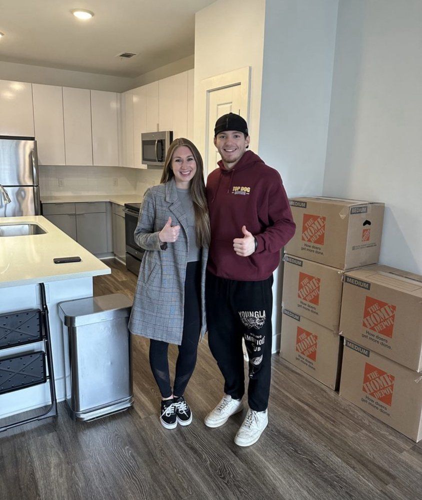A man and a woman are posing for a picture in a kitchen.