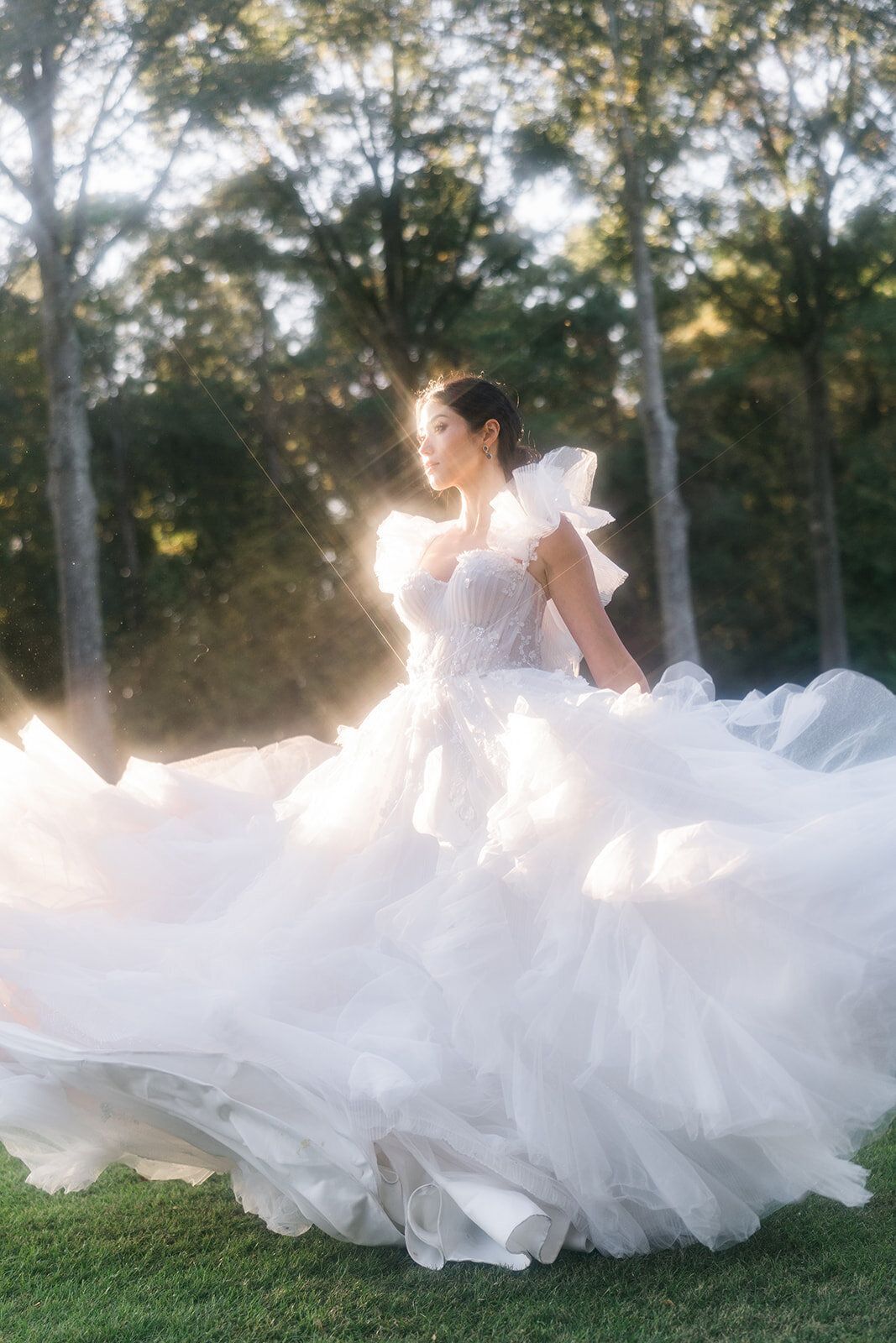 A woman in a white dress is standing in the grass.