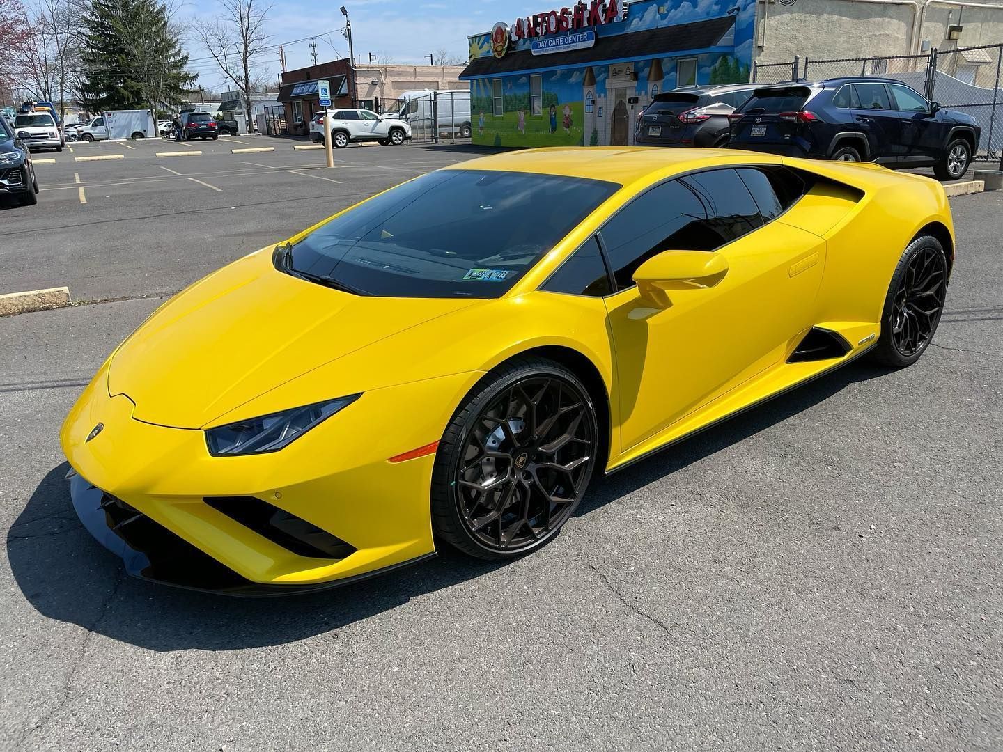 Yellow Lamborghini sports car parked in a lot.