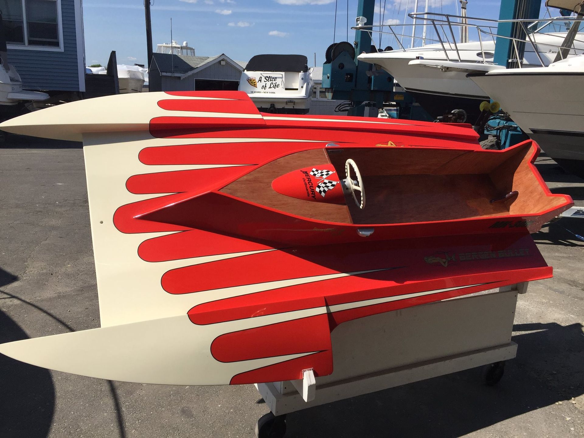 A small red and white boat is sitting on a cart