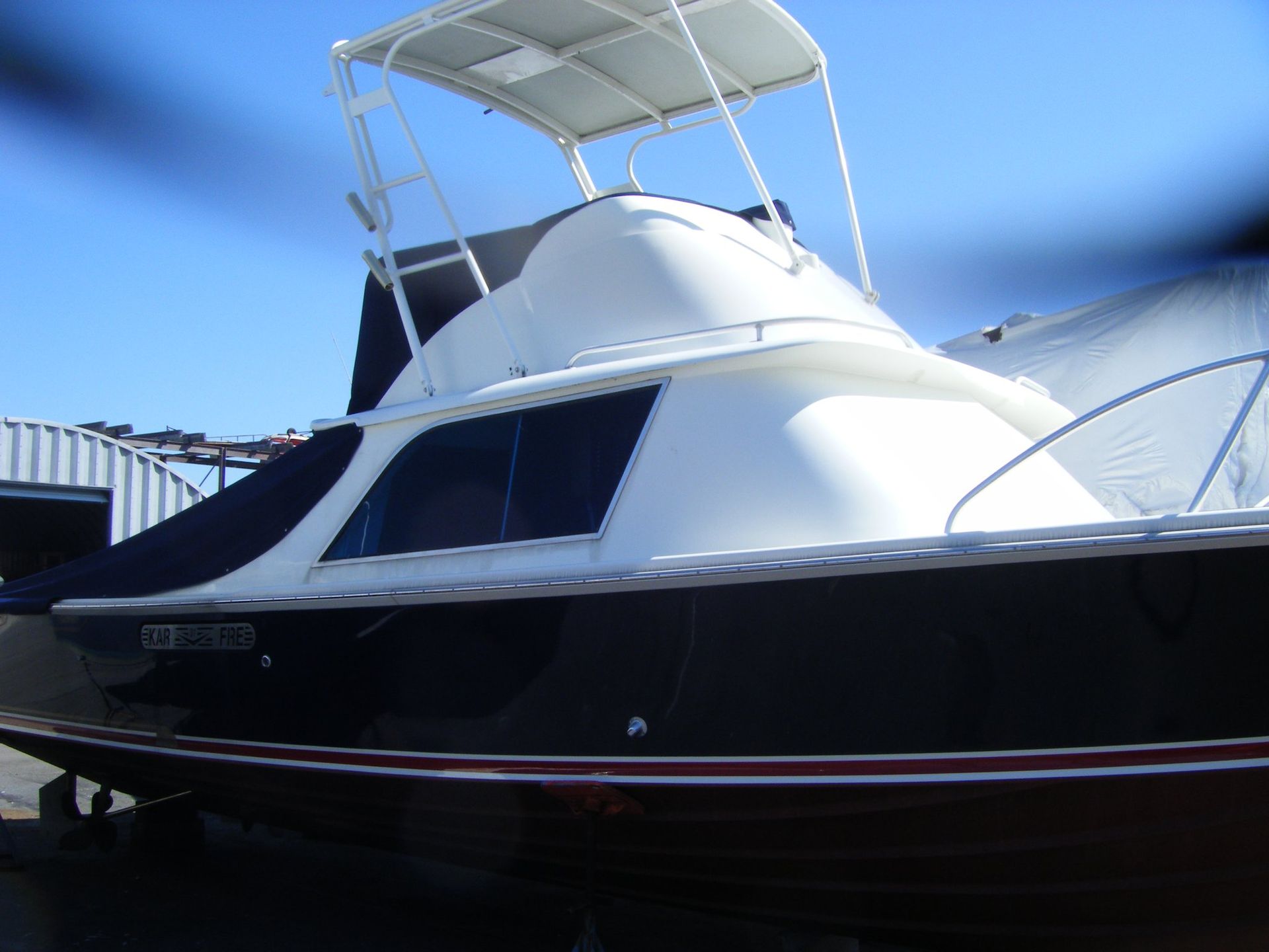A black and white boat with a license plate that says ' oe ' on it