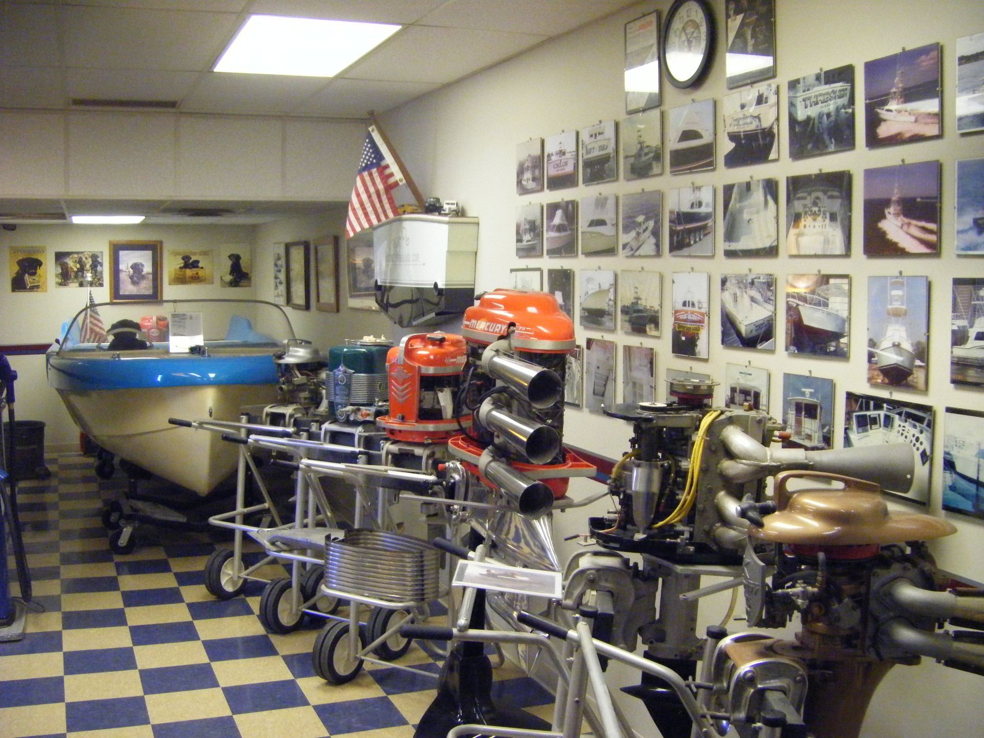 A room with a lot of pictures on the wall and a boat in the background