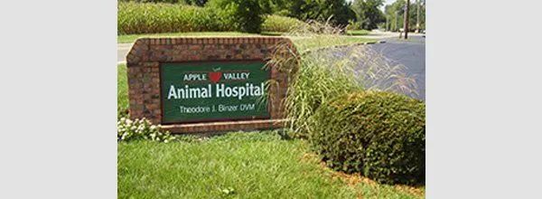 Animal Hospital sign in a landscaped grassy roadside area under a cloudy sky